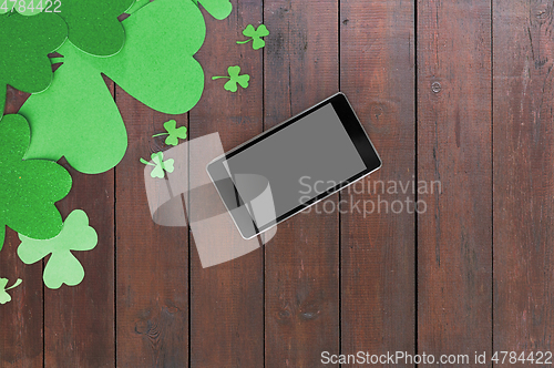 Image of tablet pc and st patricks day decorations on wood