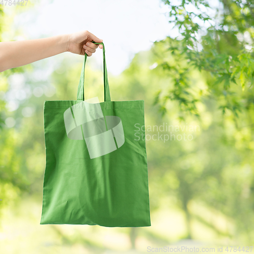 Image of hand holding reusable canvas bag for food shopping