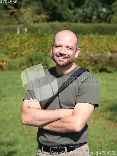 Image of man with crossed arms, beard and bald head