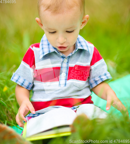 Image of Little boy is reading book