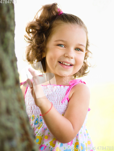 Image of Cute little girl is playing hide and seek