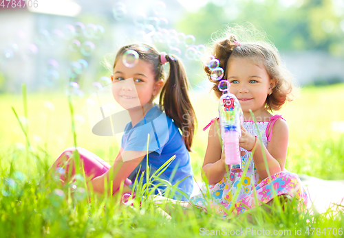 Image of Two little girls are blowing soap bubbles