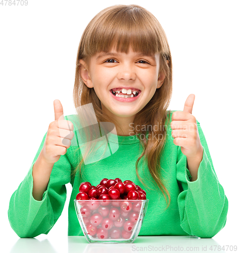 Image of Cute girl is eating cherries