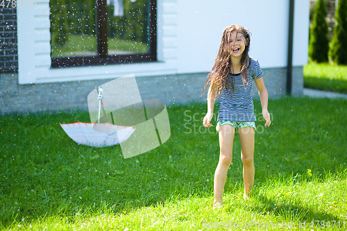 Image of Happy girl is playing under rain
