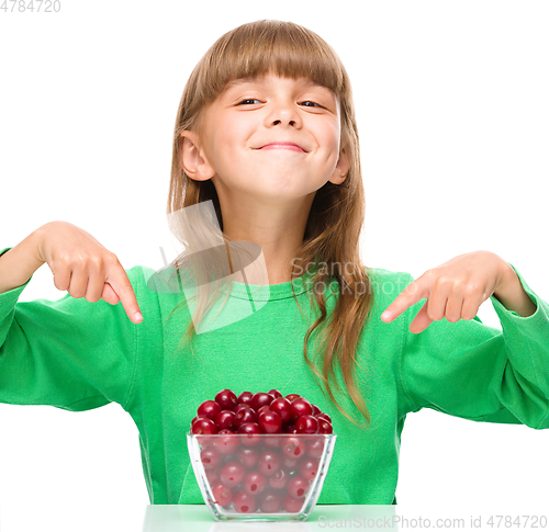 Image of Cute girl is eating cherries
