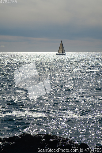 Image of sail boat at horizon line