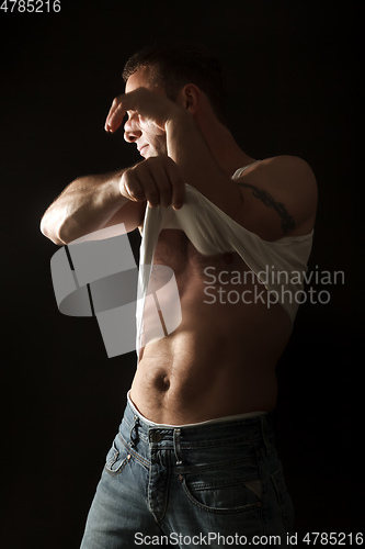 Image of handsome muscle man lifting his shirt