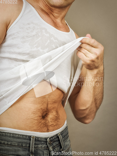Image of handsome muscle man lifting his shirt