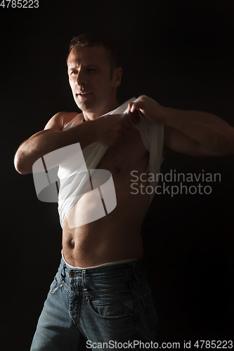 Image of handsome muscle man lifting his shirt