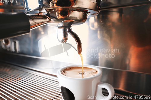 Image of Stylish black espresso making machine brewing two cups of coffee, shooted in cafe.