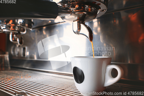 Image of Stylish black espresso making machine brewing two cups of coffee, shooted in cafe.