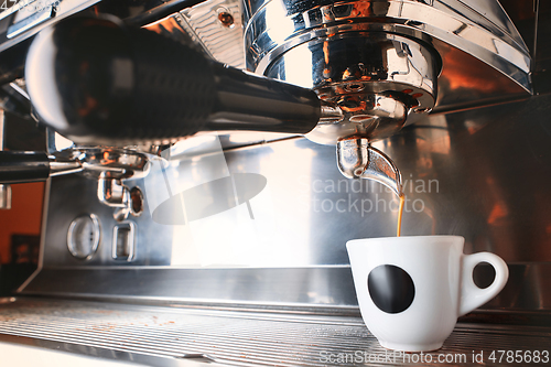 Image of Stylish black espresso making machine brewing two cups of coffee, shooted in cafe.