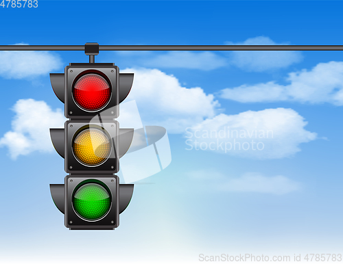 Image of Traffic lights with all three colors on hanging against blue sky