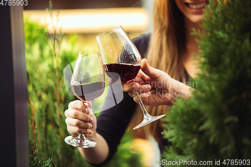 Image of People clinking glasses with wine on the summer terrace of cafe or restaurant. Close up shot, lifestyle.