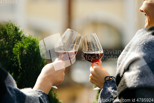 Image of People clinking glasses with wine on the summer terrace of cafe or restaurant. Close up shot, lifestyle.