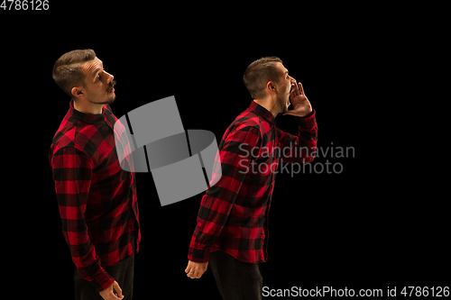 Image of Young handsome man arguing with himself on black studio background.