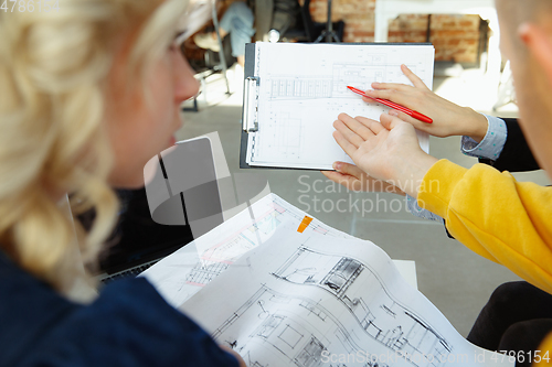 Image of Interior designer working with young couple. Lovely family and professional designer or architector.