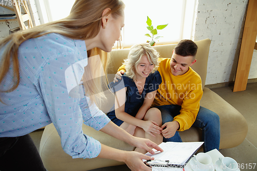 Image of Interior designer working with young couple. Lovely family and professional designer or architector.