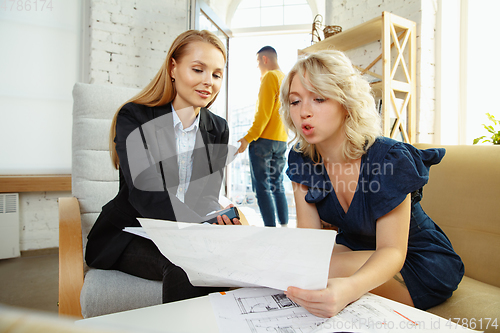 Image of Interior designer working with young couple. Lovely family and professional designer or architector.