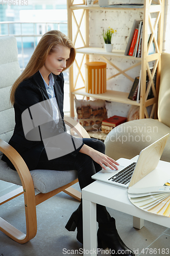 Image of Interior designer working in modern office. Young business woman in contemporary interior.