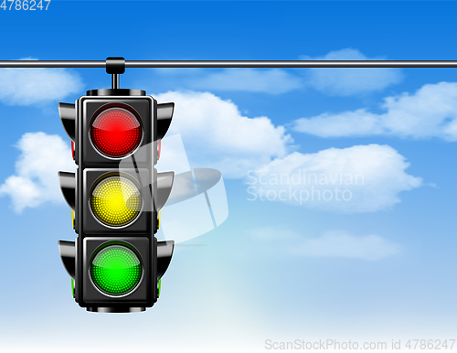 Image of Traffic lights with all three colors on hanging against blue sky