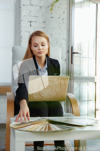 Image of Interior designer working in modern office. Young business woman in contemporary interior.