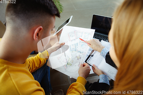 Image of Interior designer working with young couple. Lovely family and professional designer or architector.