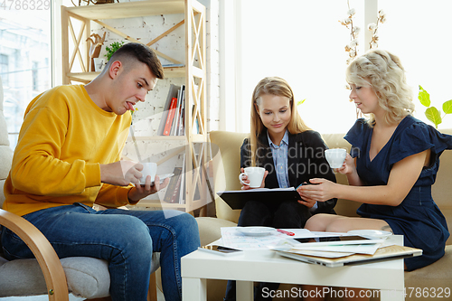 Image of Interior designer working with young couple. Lovely family and professional designer or architector.