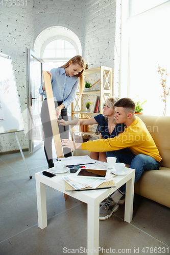 Image of Interior designer working with young couple. Lovely family and professional designer or architector.