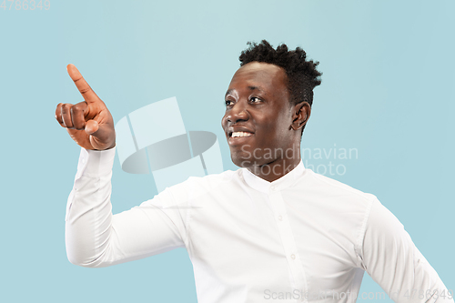 Image of Young african-american man isolated on blue studio background, human emotions concept.