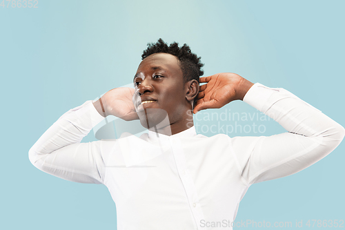 Image of Young african-american man isolated on blue studio background, human emotions concept.