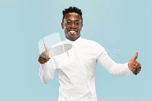 Image of Young african-american man isolated on blue studio background, human emotions concept.