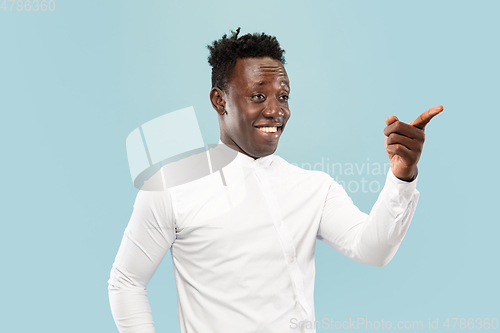 Image of Young african-american man isolated on blue studio background, human emotions concept.