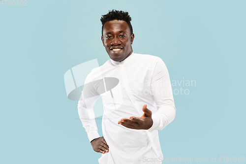 Image of Young african-american man isolated on blue studio background, human emotions concept.