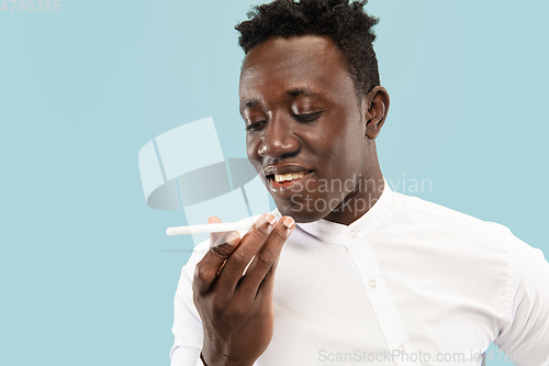 Image of Young african-american man isolated on blue studio background, human emotions concept.