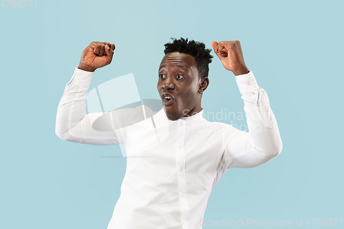 Image of Young african-american man isolated on blue studio background, human emotions concept.