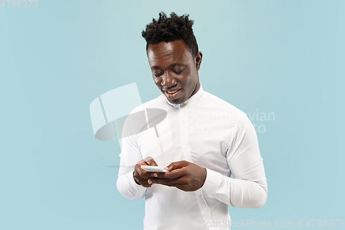 Image of Young african-american man isolated on blue studio background, human emotions concept.