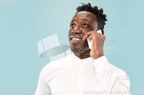 Image of Young african-american man isolated on blue studio background, human emotions concept.