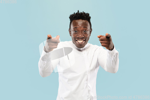 Image of Young african-american man isolated on blue studio background, human emotions concept.