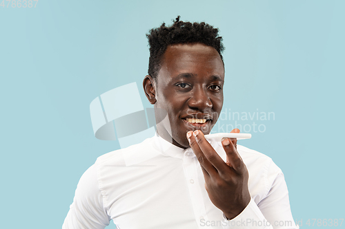 Image of Young african-american man isolated on blue studio background, human emotions concept.