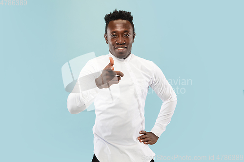 Image of Young african-american man isolated on blue studio background, human emotions concept.