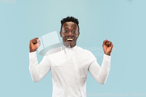 Image of Young african-american man isolated on blue studio background, human emotions concept.