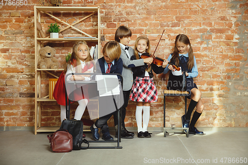 Image of Group of kids spending time after school together. Handsome friends resting after classes.