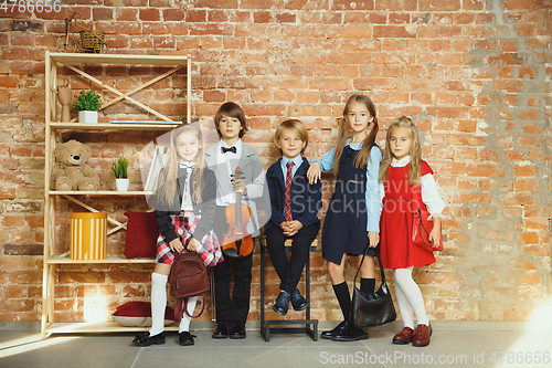 Image of Group of kids spending time after school together. Handsome friends resting after classes.