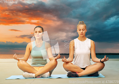 Image of women doing yoga and meditating in lotus pose