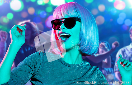 Image of woman in wig and sunglasses dancing at nightclub