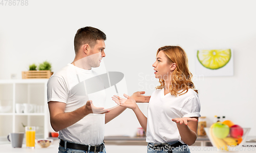 Image of unhappy couple having argument at kitchen