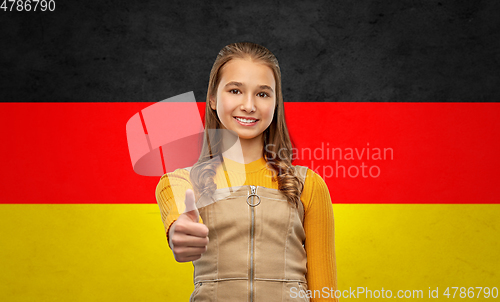 Image of teenage girl showing thumbs up over german flag