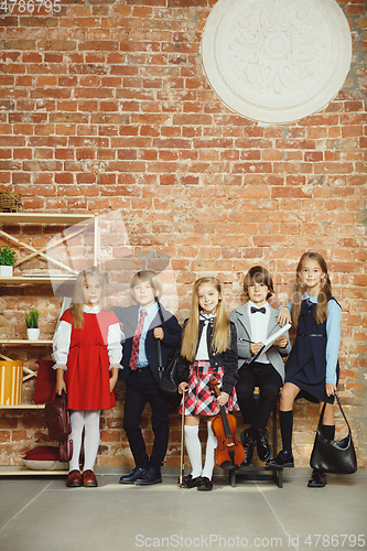 Image of Group of kids spending time after school together. Handsome friends resting after classes.