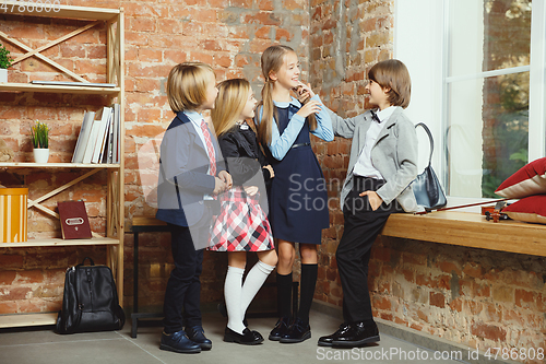 Image of Group of kids spending time after school together. Handsome friends resting after classes.